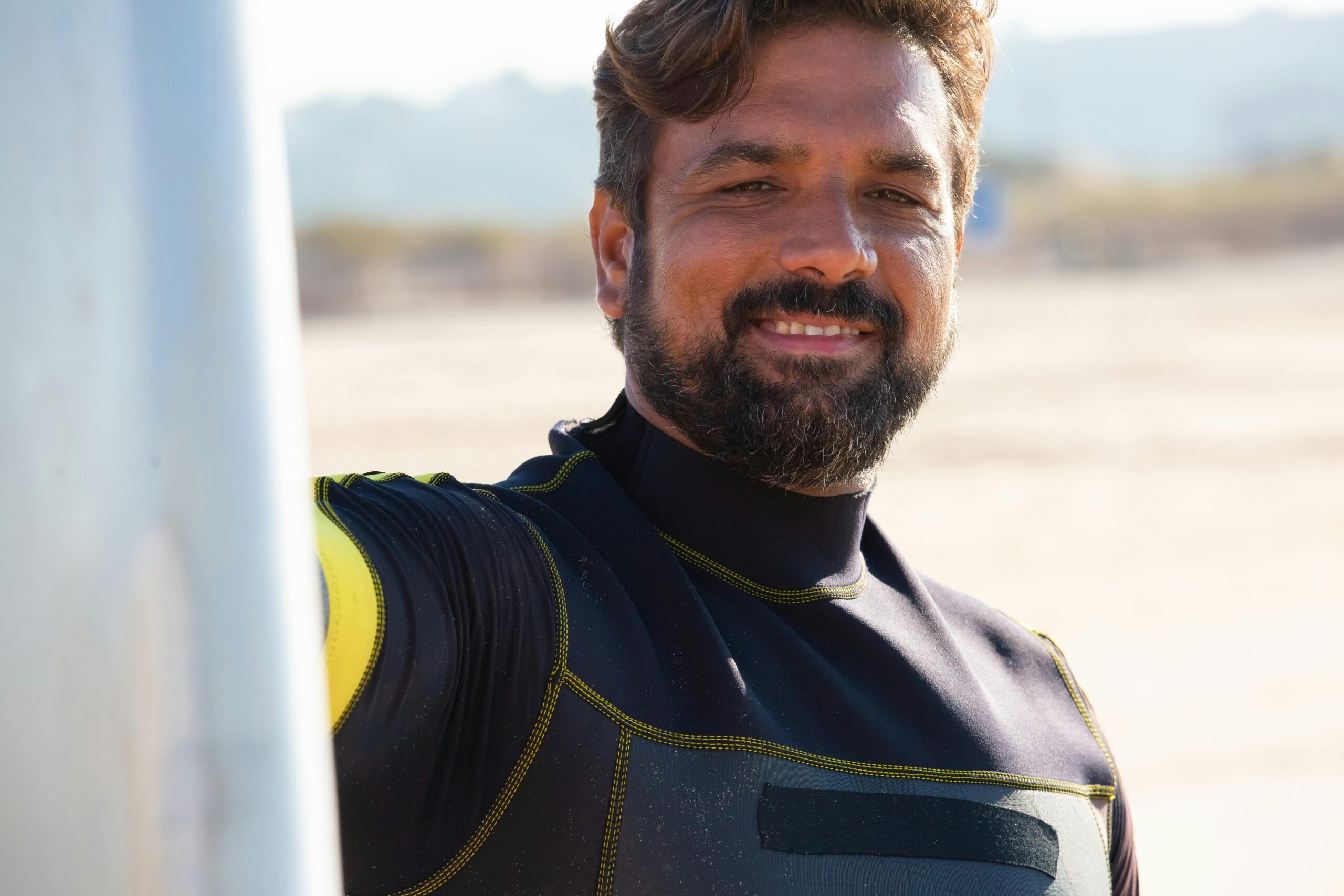 Ernten Sie Ethnischen Männlichen Surfer, Der Auf Seeküste Steht