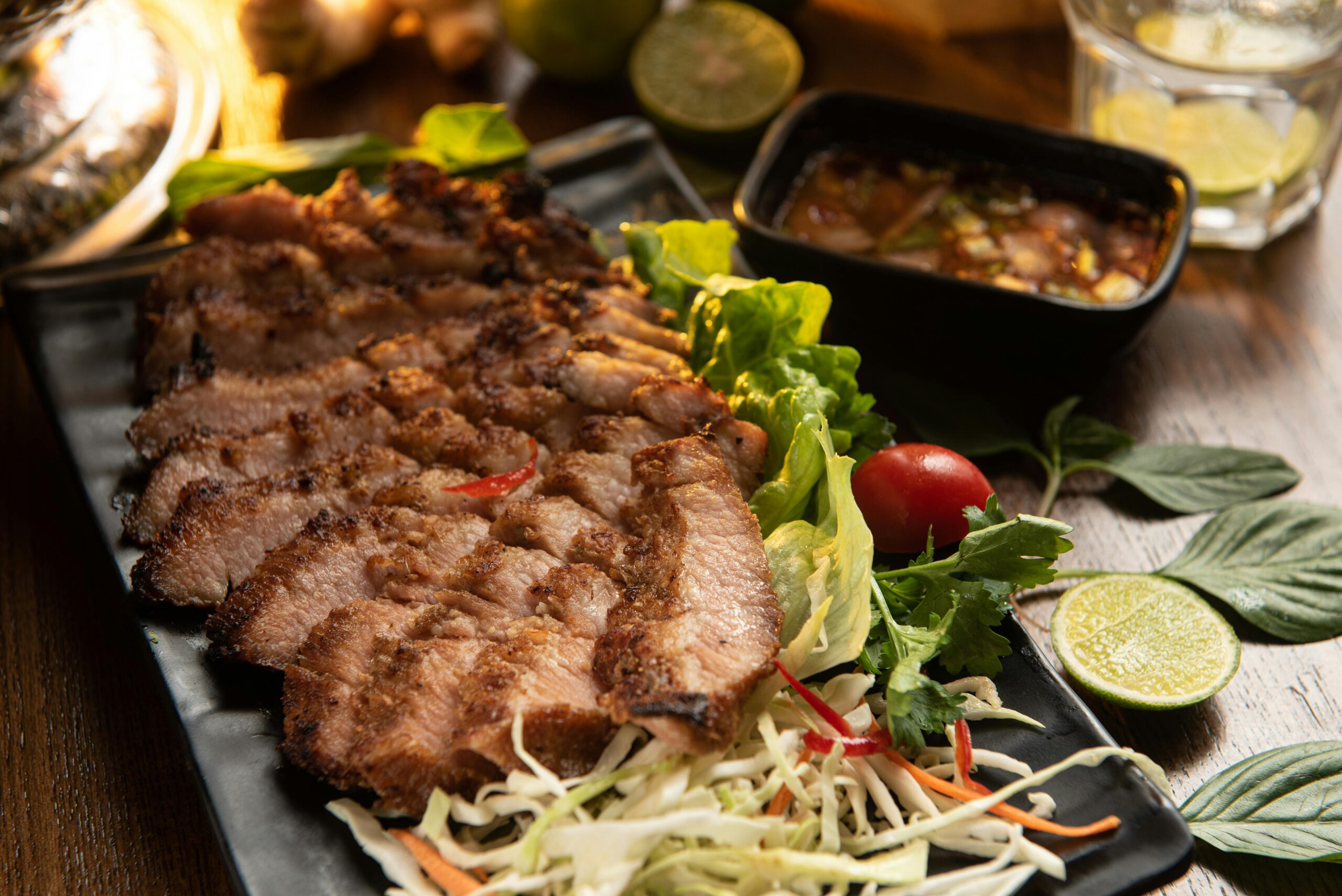 Köstliches gegrilltes Schweinefleisch, serviert mit frischem Gemüse und einer würzigen Dip-Sauce.
