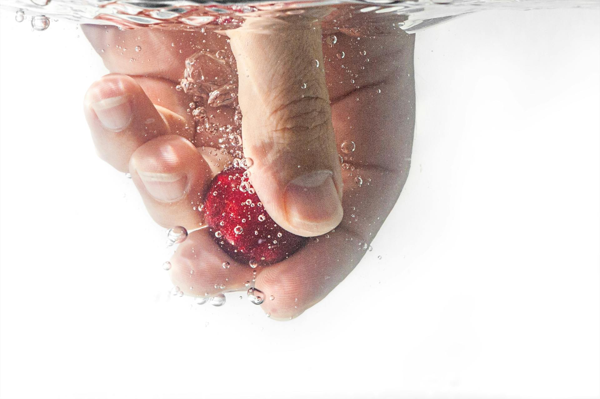 Person, Die Roten Ball Unter Wasser Hält